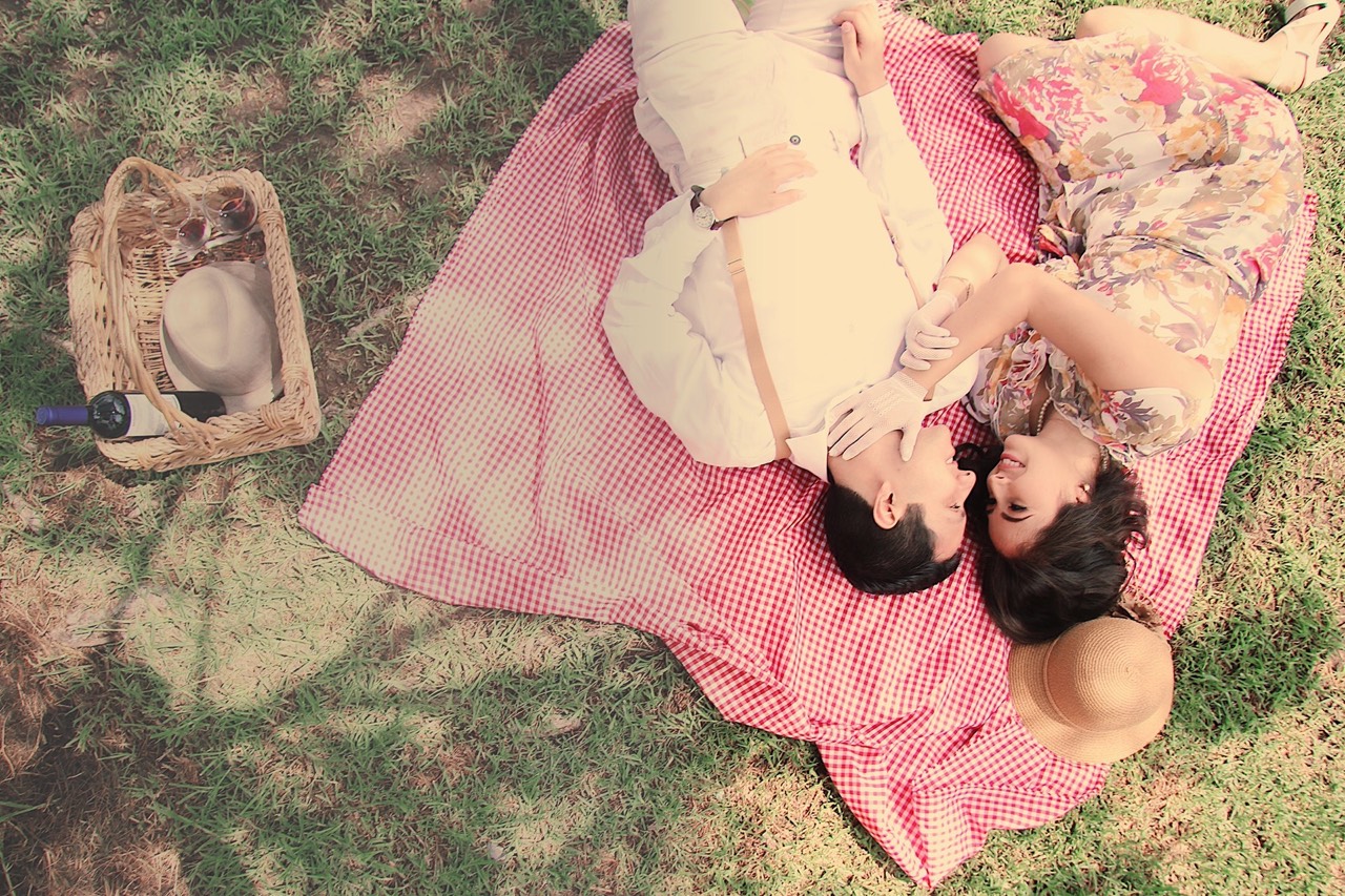 Bianca y Ricardo compartiendo un picnic sobre el césped